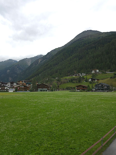 Wide green meadow, a few houses and behind them the Sölderkogl. A beautiful view from Apart Tyrolis